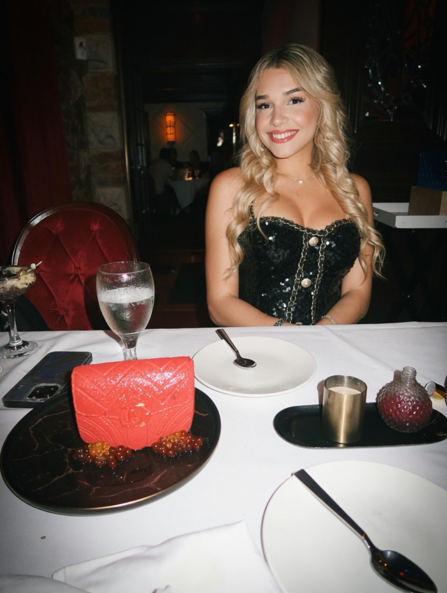 A dark restaurant, white tablecloth, dessert arriving, candlelight.