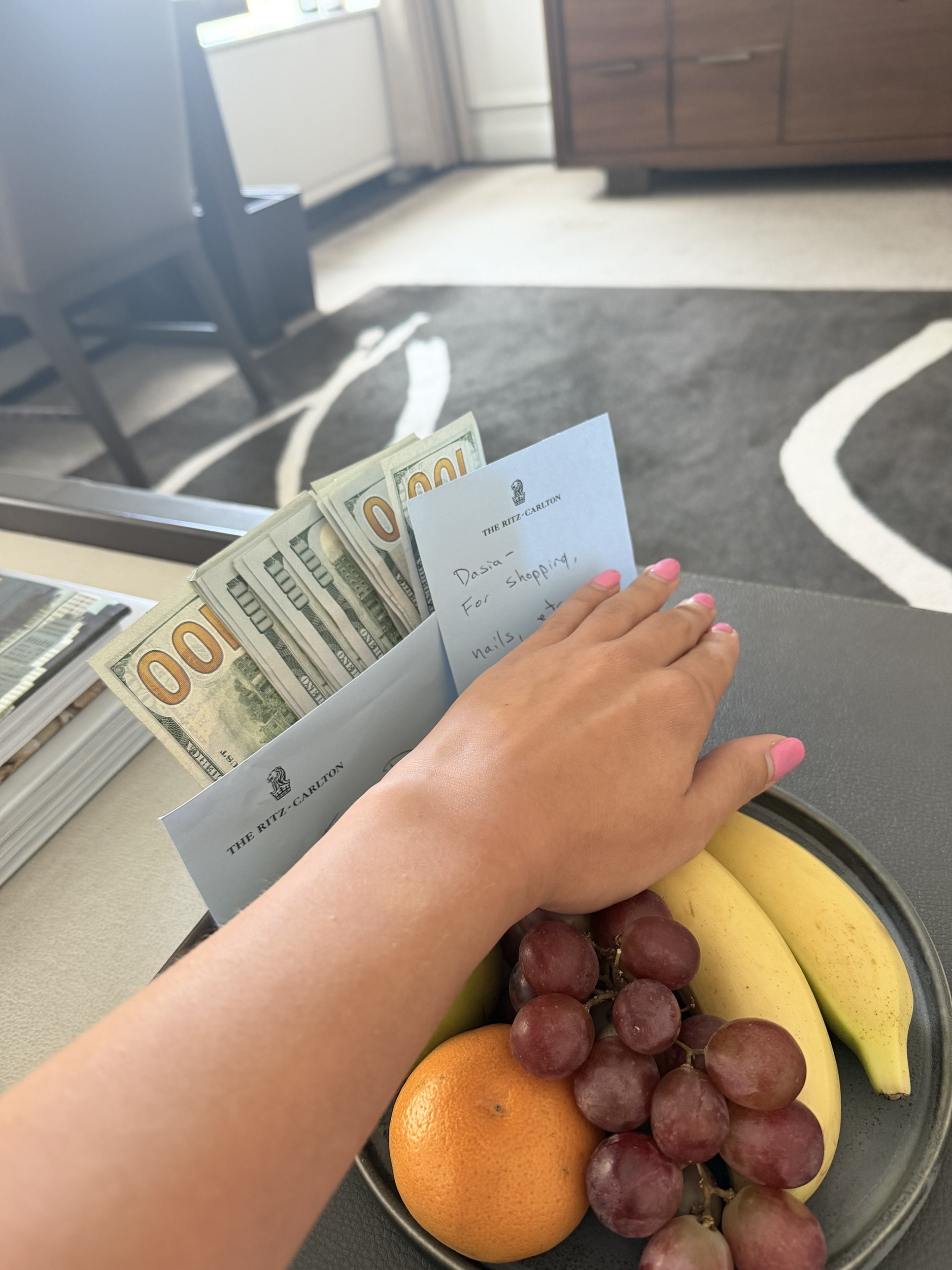 A handwritten note left on a tray beside a bowl of fruit.