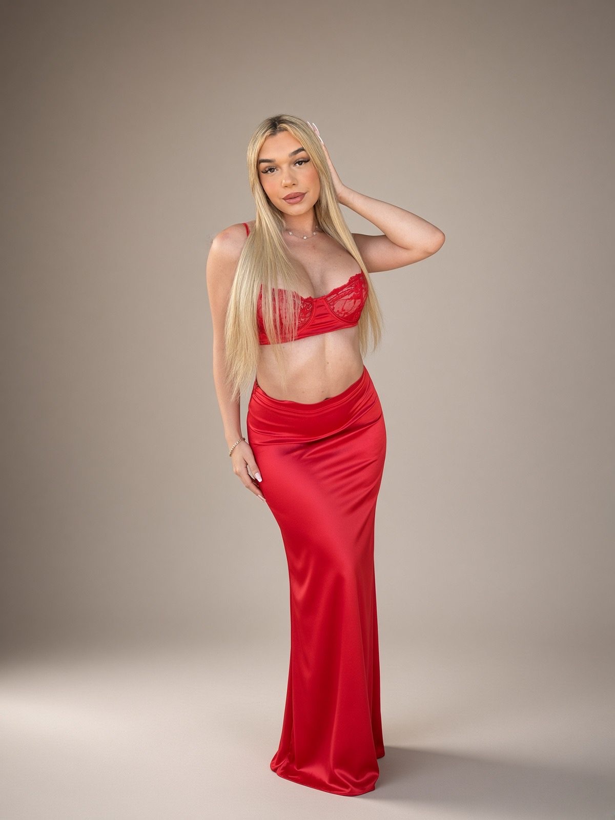 A red gown standing still in warm light.